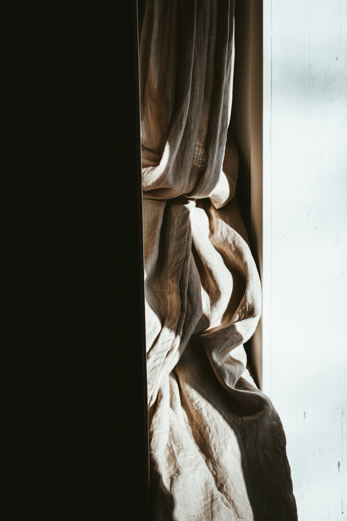 Undyed linen folded beside plain pottery in daylight