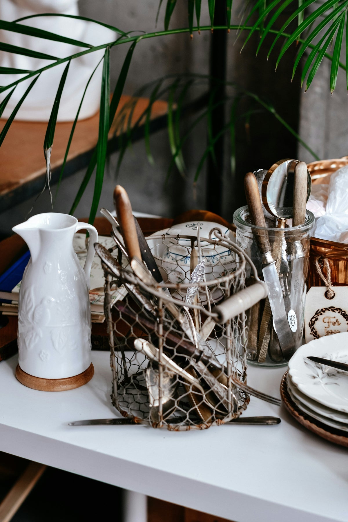 Wooden utensils and a stoneware pitcher on a kitchen counter